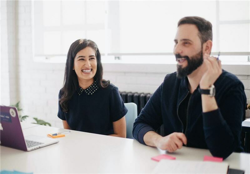 Man and woman in office smiling